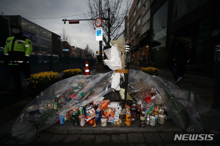 [서울=뉴시스] 김선웅 기자 = 10·29 이태원 참사 이후 1개월이 지난달 28일 서울 용산구 이태원 참사 현장 인근에 추모객들이 놓은 술과 음료, 국화꽃 등이 비닐에 덮여 있다. 2022.11.28. mangusta@newsis.com