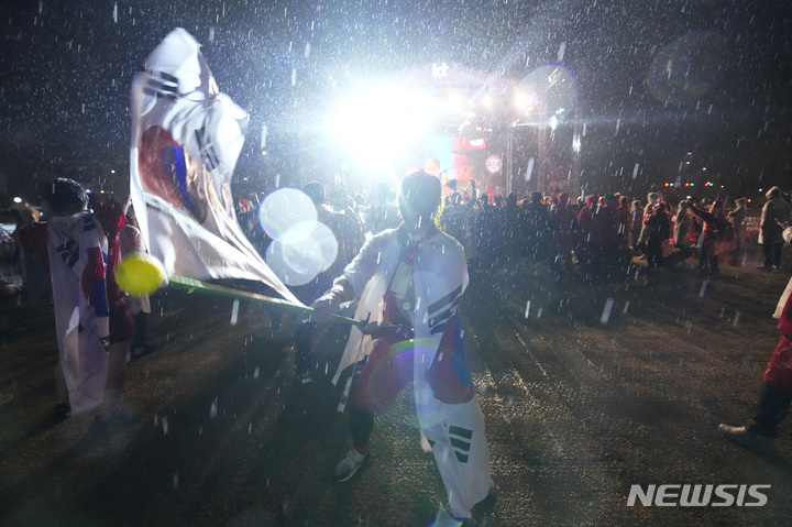 [서울=AP/뉴시스] 대한민국 축구 팬이 28일(현지시간) 대한민국 서울 광화문 광장 거리에서 월드컵 H조 가나와 한국의 경기가 생중계되고 있는 가운데 한국 팀을 위해 태극기를 흔들고 있다. 2022.11.29.