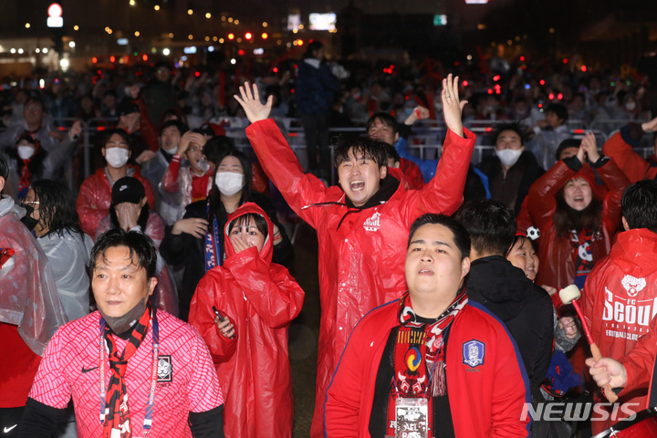 [서울=뉴시스] 김진아 기자 = 2022 카타르월드컵 조별리그 2차전 대한민국과 가나와의 경기가 열리는 28일 서울 종로구 광화문광장에 설치된 대형스크린으로 경기를 시청하던 붉은악마들이 대한민국이 득점하자 기뻐하고 있다. 2022.11.28. bluesoda@newsis.com