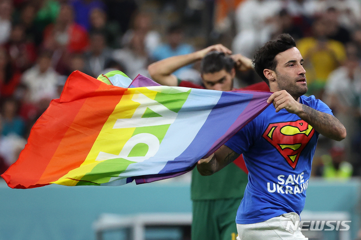 [루사일(카타르)=뉴시스] 조성우 기자 = 28일(현지시간) 카타르 루사일 스타디움에서 열린 2022 카타르 월드컵 조별리그 조별리그 H조 2차전 포르투갈과 우루과이의 경기, 한 남성이 경기장에 난입해 무지개 깃발을 흔들고 있다. 2022.11.29. xconfind@newsis.com