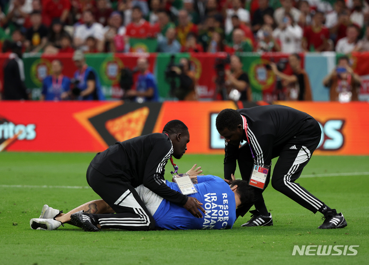 [루사일(카타르)=뉴시스] 조성우 기자 = 28일(현지시간) 카타르 루사일 스타디움에서 열린 2022 카타르 월드컵 조별리그 조별리그 H조 2차전 포르투갈과 우루과이의 경기, 한 남성이 '이란 여성에 대한 존중'이라고 적힌 티셔츠를 입고 경기장에 난입하자 경비에게 제압 당하고 있다. 2022.11.29. xconfind@newsis.com