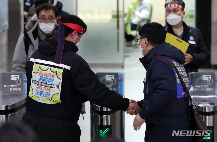 [서울=뉴시스] 이영환 기자 = 서울교통공사 노사가 협상을 타결한 1일 새벽 서울 성동구 서울교통공사 본사에서 명순필 서울교통공사 노조위원장이 동료들과 악수를 하고 있다. 2022.12.01. 20hwan@newsis.com