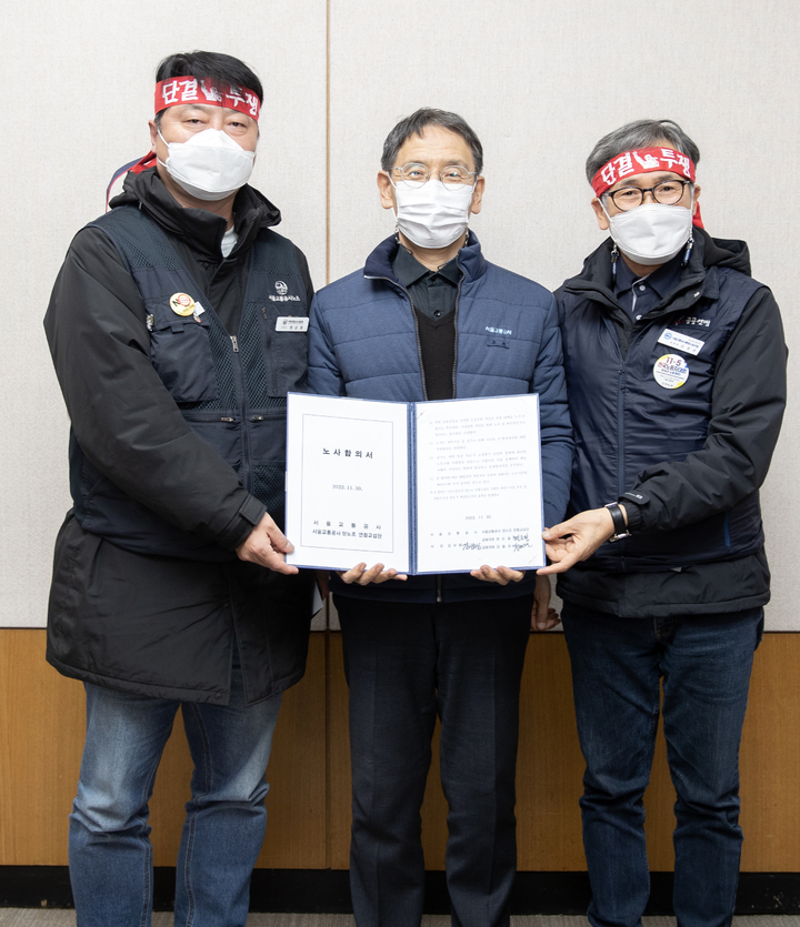 [서울=뉴시스] 이영환 기자 = 서울교통공사 노사가 협상을 타결한 1일 새벽 서울 성동구 서울교통공사 본사에서 명순필(왼쪽부터) 서울교통공사 노조위원장, 김상범 서울교통공사 사장, 김철관 서울교통공사통합노조위원장이 노사합의서를 들고 기념촬영을 하고 있다. (사진=서울교통공사 제공) 2022.12.01. photo@newsis.com *재판매 및 DB 금지