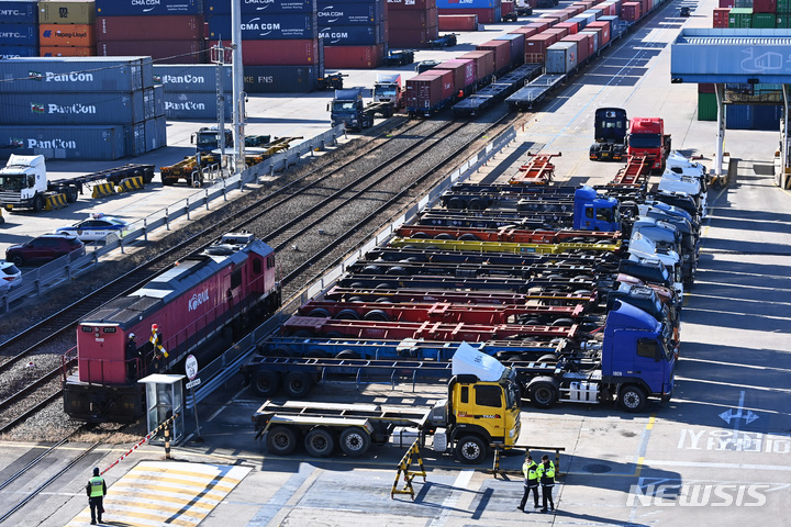 [의왕=뉴시스] 김종택 기자 = 전국철도노동조합이 예고한 파업 시한을 하루 앞둔 1일 경기도 의왕시 내륙컨테이너기지(ICD)에서 화물을 실은 열차가 파업으로 멈춰 선 트럭 옆으로 지나가고 있다. 화물연대의 파업이 계속되고 철도노조도 오는 2일 전면파업을 예고하면서 사상 처음으로 도로와 철도의 운송이 동시에 막히는 '교통 총파업' 사태위기가 예상되고 있다. 2022.12.01. jtk@newsis.com