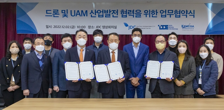 [제주=뉴시스] 2일 ‘드론 및 UAM 산업발전 협력을 위한 업무협약’을 한 제주국제자유도시개발센터(JDC), 데이터디자인엔지니어링(DDE), 켄코아에어로스페이스(KENCOA) 관계자들이 기념촬영을 하고 있다. (사진=제주국제자유도시개발센터 제공) 2022.12.02. photo@newsis.com *재판매 및 DB 금지