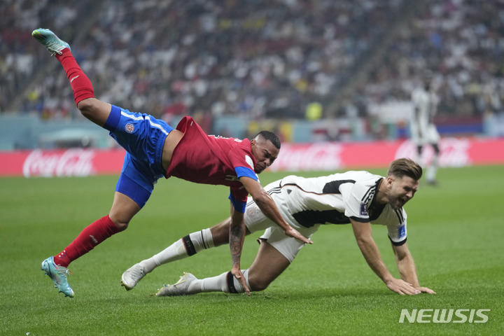 [알 코르=AP/뉴시스] 코스타리카의 카를로스 마르티네즈가 1일(현지시간) 카타르 알 코르 알 바이트 경기장에서 열린 코스타리카와 독일의 월드컵 E조 경기에서 독일의 니클라스 픨크루와 넘어지고 있다. 2022.12.02.