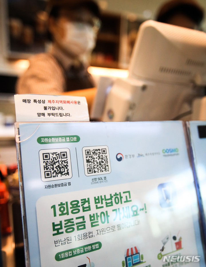 [제주=뉴시스] 우장호 기자 = 2일부터 제주에서 일회용컵에 음료를 받으려면 컵 보증금 300원을 지불해야 한다. 정부는 일회용 폐기물을 줄이기 위해 이날부터 제주와 세종에서 '일회용컵 보증금' 제도를 시범 실시한다. 사진은 보증금제 시행을 알리는 안내문이 게시된 제주국제공항내 프랜차이즈 매장 모습. 2022.12.02. woo1223@newsis.com