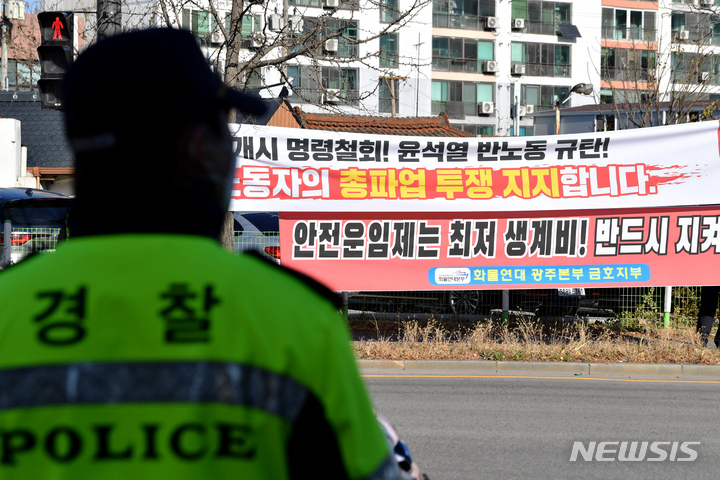 [광주=뉴시스] 이영주 기자 = 화물연대 파업 9일차를 맞은 지난 2일 오후 광주 광산구 금호타이어 공장 앞에서 열린 화물연대 광주지역본부의 총력투쟁 결의대회 도중 경찰이 현장 교통 통제를 하고 있다.  2022.12.02. leeyj278@newsis.com