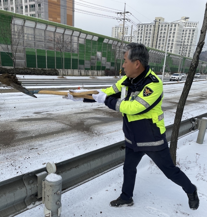 [청주=뉴시스] 조성현 기자 = 1㎝ 안팎의 눈이 내린 6일 오전 빙판길로 변한 충북 청주 도심 도로 곳곳에서 상당경찰서 교통관리계 이원태 경감이 제설 작업을 하고 있다. (사진=충북경찰청 제공) 2022.12.06. photo@newsis.com&nbsp; *재판매 및 DB 금지
