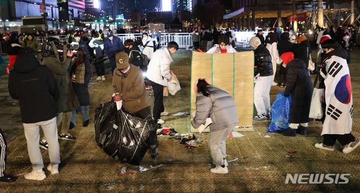 [서울=뉴시스] 조수정 기자 = 6일 오전 서울 광화문광장에서 붉은악마와 시민들이 월드컵 16강전 대한민국과 브라질의 경기 거리응원을 마친 뒤 쓰레기를 스스로 치우고 있다. 2022.12.06. chocrystal@newsis.com