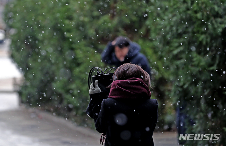 [서울=뉴시스] 김금보 기자 = 눈이 내린 6일 오전 서울 중구 한 거리에서 한 시민이 가방으로 눈발을 피하며 이동하고 있다. 2022.12.06. kgb@newsis.com