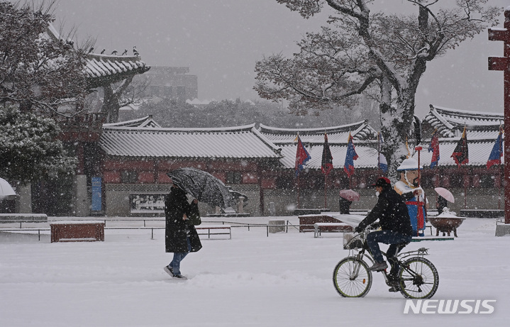 [수원=뉴시스] 김종택 기자 = 절기상 대설(大雪)을 하루 앞둔 6일 경기도 수원시 팔달구 화성행궁에서 시민들이 함박눈을 맞으며 걸어가고 있다. 2022.12.06. jtk@newsis.com