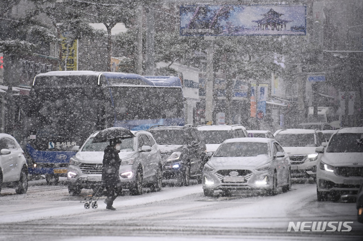 [수원=뉴시스] 김종택 기자 = 절기상 대설(大雪)을 하루 앞둔 6일 경기도 수원시 팔달구 화성행궁에서 시민들이 함박눈을 맞으며 걸어가고 있다. 2022.12.06. jtk@newsis.com