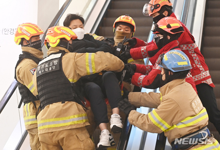 [수원=뉴시스] 김종택 기자 = 8일 오전 경기도 수원시 권선구 롯데몰 수원점에서 열린 '2022 사회재난 합동훈련'에서 119 구조대원들이 에스컬레이터 역주행으로 압사 사고를 가장한 인명구조 훈련을 하고 있다. 2022.12.08. jtk@newsis.com