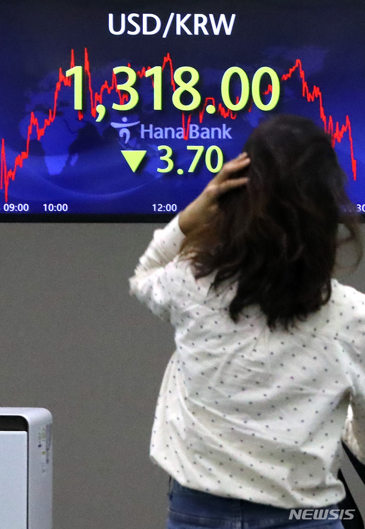 [서울=뉴시스] 최진석 기자 = 서울 외환시장에서 원·달러 환율은 전 거래일(1321.7원)보다 3.7원 내린 1318.0원에 마감한 8일 오후 서울 중구 하나은행 본점에서 딜러가 업무를 보고 있다. 2022.12.08. myjs@newsis.com