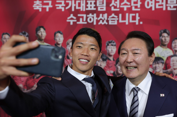 [서울=뉴시스] 윤석열 대통령이 8일 청와대 영빈관에서 열린 카타르 월드컵 축구 국가대표팀 환영 만찬을 마친 뒤 황희찬 선수와 셀카를 찍고 있다. (사진=대통령실 제공) 2022.12.08. photo@newsis.com *재판매 및 DB 금지