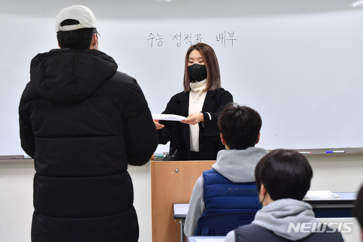 [서울=뉴시스] 최진석 기자 = 2023학년도 수능 성적표 배부일인 9일 오전 서울 종로구 경복고등학교에서 담임 교사가 고3 수험생들에게 성적표를 배부하고 있다. (공동취재사진) 2022.12.09. photo@newsis.com