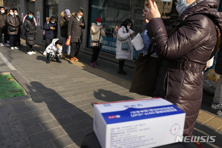 [베이징=AP/뉴시스] 9일 중국 베이징의 한 약국에 약을 사려는 주민들이 줄을 서 있다. 중국은 일상 회복을 위한 '제로 코로나' 정책을 사실상 폐지했으나 전문가들은 갑작스러운 방역 완화로 전 인구의 80~90%가 결국 코로나19에 감염될 수도 있다고 경고하고 있다. 2022.12.09