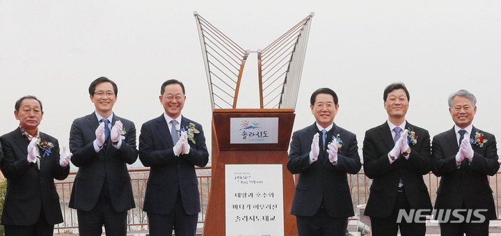 [영암=뉴시스] 이창우 기자=해남 산이면 대진리와 영암 삼호읍 서호리 잇는 영암·해남 관광레저형 기업도시 진압도로 개통식이 9일 오후 영암군 삼호읍 솔라시도대교 유지관리사무소에서 열린 가운데 김영록 전남도지사(오른쪽 세 번째), 서동욱 도의회 의장, 명현관 해남군수, 우승희 영암군수 등 내빈들이 준공 기념비 제막을 하고 있다. (사진=전남도 제공) 2022.12.09. photo@newsis.com *재판매 및 DB 금지