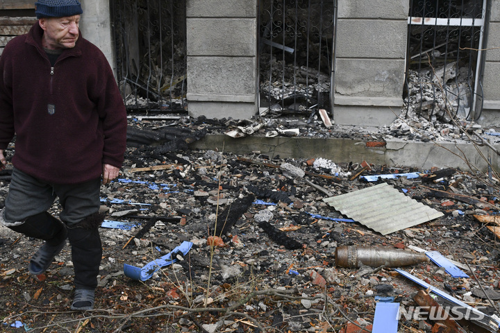 [바흐무트=AP/뉴시스] 11일(현지시간) 우크라이나 도네츠크주 바흐무트에서 한 주민이 불발탄을 바라보며 지나가고 있다. 2022.12.12.