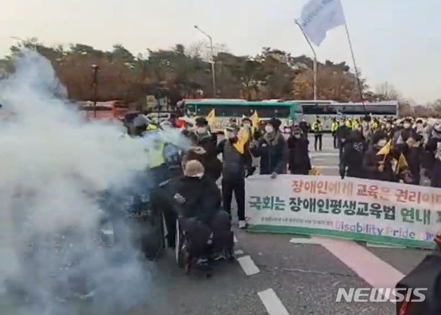 [서울=뉴시스] 전재훈 기자 = 지난해 11월17일 진행된 장애인 교육권 보장 집회·시위에서 박경석 전국장애인차별철폐연대(전장연) 상임공동대표가 연막탄을 들고 있다. (사진=전장연) 2022.12.13.