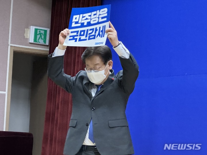 [대전=뉴시스] 김도현 기자 = 이재명 더불어민주당 대표가 13일 대전 대덕구 유성문화원에서 열린 '찾아가는 국민보고회 대전·세종편'에서 '민주당은 국민감세' 내용이 담긴 피켓을 들고 있다. 2022.12.13. photo@newsis.com