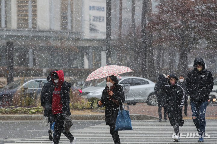 [서울=뉴시스] 권창회 기자 = 서울을 비롯한 수도권에 눈이 내리고 있는 13일 오후 서울 송파구 잠실역 인근에서 시민들이 우산을 쓰고 이동하고 있다 2022.12.13. kch0523@newsis.com