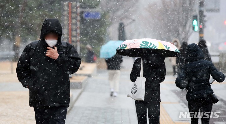 [서울=뉴시스] 김선웅 기자 = 13일 오후 서울 중구 태평로에서 내리는 눈 사이로 시민들이 길을 걷고 있다. 2022.12.13. mangusta@newsis.com