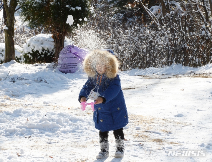 [청주=뉴시스] 조성현 기자 = 대설특보가 해제된 14일 오전 충북 청주시 서원구 산남동 원흥이 생태공원에서 한 어린이가 밤새 쌓인 눈을 만지며 놀고 있다. 2022.12.14. jsh0128@newsis.com 