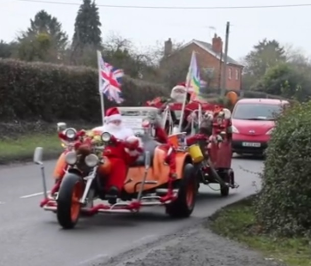 [서울=뉴시스] 믹 워럴(75)가 20년 째 몰고 있는 3륜 크리스마스 오토바이, 워럴은 영국 우스터셔주에서 선물을 나눠주다 '보도 운전 혐의'로 벌금이 부과됐다 (사진출처: 데일리메일 동영상 캡처) 2022.12.14. *재판매 및 DB 금지