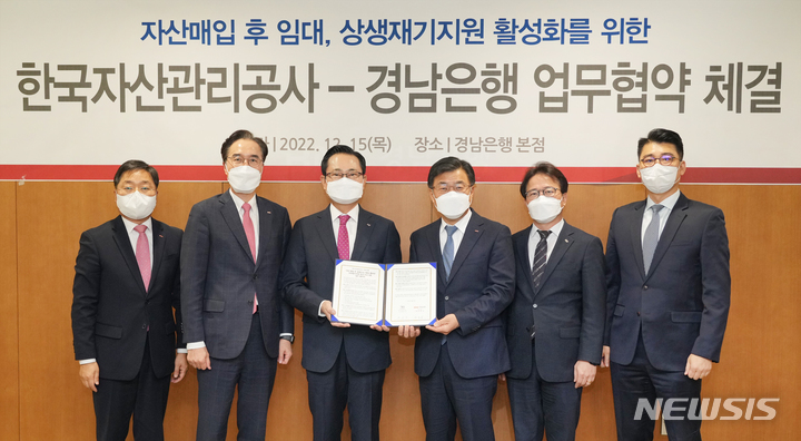 [창원=뉴시스] 홍정명 기자=15일 BNK경남은행 창원 본점 회의실에서 최홍영(오른쪽 세 번째) 은행장과 캠코 권남주(왼쪽 세 번째) 사장이 ‘자산 매입 후 임대 프로그램을 활용한 상생재기지원 촉진 프로그램 업무협약’을 체결한 후 기념촬영을 하고 있다.(사진=BNK경남은행 제공)2022.12.15. photo@newsis.com