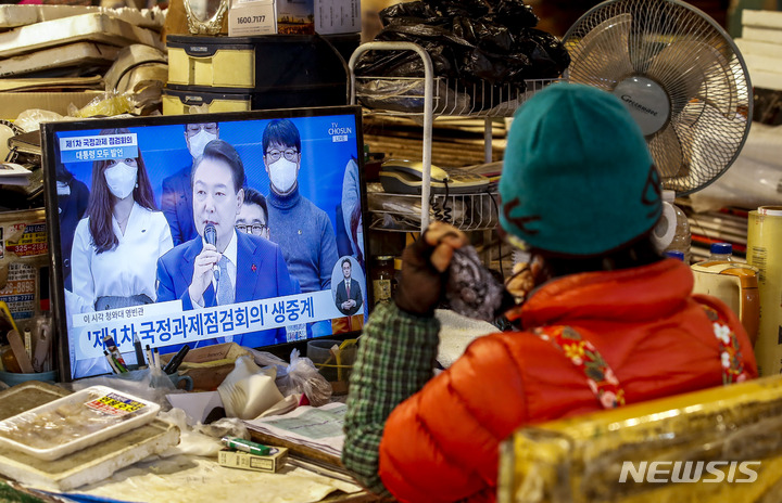 [서울=뉴시스] 정병혁 기자 = 15일 서울 서대문구 인왕시장에서 상인들이 윤석열 대통령의 제1차 국정과제 점검회의 생중계를 시청하고 있다. 2022.12.15. jhope@newsis.com