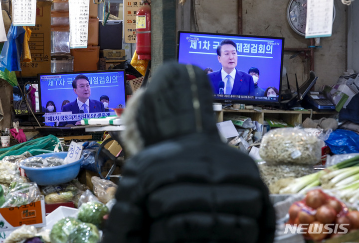 [서울=뉴시스] 정병혁 기자 = 지난해 12월15일 서울 서대문구 인왕시장에서 상인들이 윤석열 대통령의 제1차 국정과제 점검회의 생중계를 시청하고 있다. 2022.12.15. jhope@newsis.com