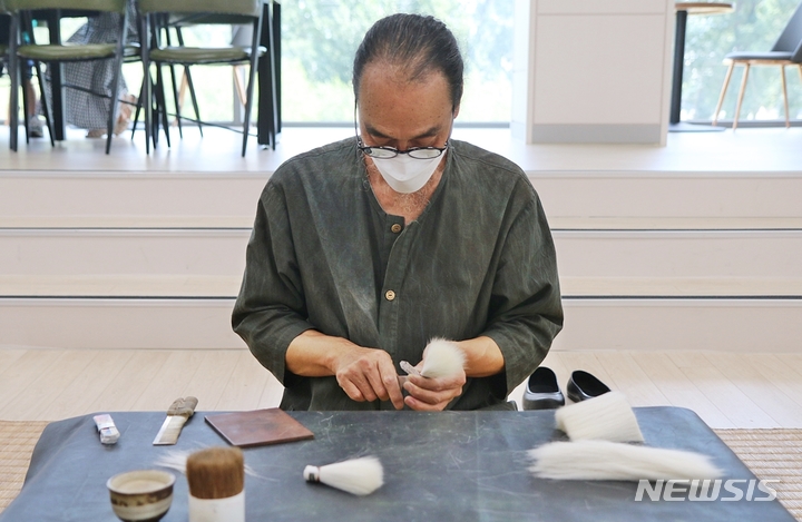 [증평=뉴시스] 강신욱 기자 = 충북 증평군 도안면 화성3리가 농림축산식품부의 2023년 농촌축제 지원사업 공모에 선정돼 내년에 '붓마을 작다리축제'를 연다. 사진은 이 마을에 작업장을 둔 충북도 무형문화재 유필무 필장이 지난 7월2일 독서왕김득신문학관에서 열린 충북도 무형문화재 공개행사에서 붓털 제작을 시연하고 있다. 2022.12.16. ksw64@newsis.com