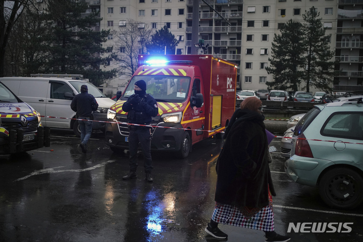 [리옹(프랑스)=AP/뉴시스]프랑스 중부 리옹 외곽의 보앙블렝 마을의 8층짜리 아파트에서 16일 새벽(현지시간) 화재가 발생, 어린이 5명을 포함해 10명이 숨지고 14명이 부상했다. 출동한 소방관들이 소방차 옆에 서 있다. 2022.12.16