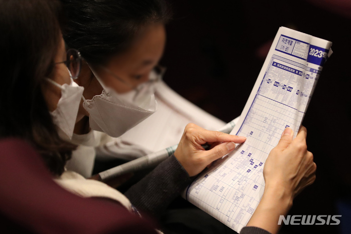 [서울=뉴시스] 백동현 기자 =지난 19일 오후 서울 송파구 롯데시네마 월드타워점에서 열린 2023학년도 대입 정시 입시전략 설명회에서 수험생과 학부모가 함께 지원가능 대학·학과 참고자료를 살펴보고 있다. 2022.12.20. livertrent@newsis.com