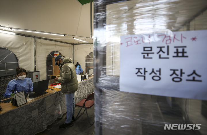 [서울=뉴시스] 정병혁 기자 = 20일 오전 서울 용산구보건소 코로나19 선별진료소를 찾은 시민들이 검사를 받기 위해 문진표를 작성하고 있다. 2022.12.20. jhope@newsis.com