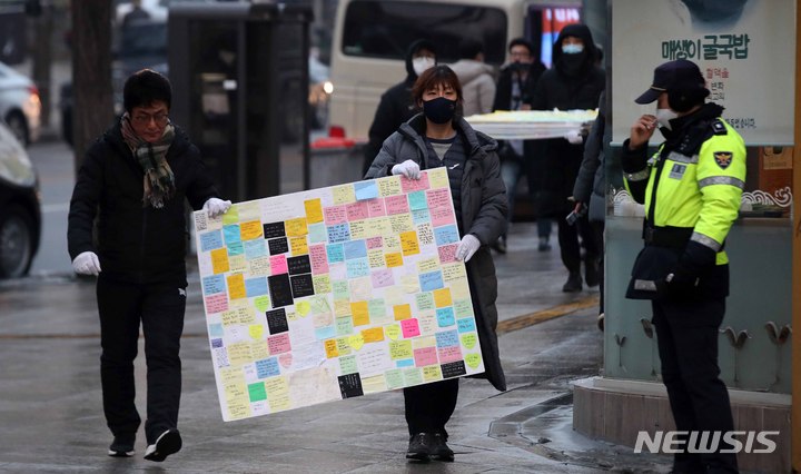 [서울=뉴시스] 김선웅 기자 = 이태원 참사 유가족협의회, 이태원 상인회, 자원봉사자 등이 21일 서울 용산구 이태원역 인근에 마련된 추모공간에서 참사 추모물품과 추모메시지 등을 정리한 후 녹사평역 합동분향소로 옮기고 있다. 2022.12.21. mangusta@newsis.com