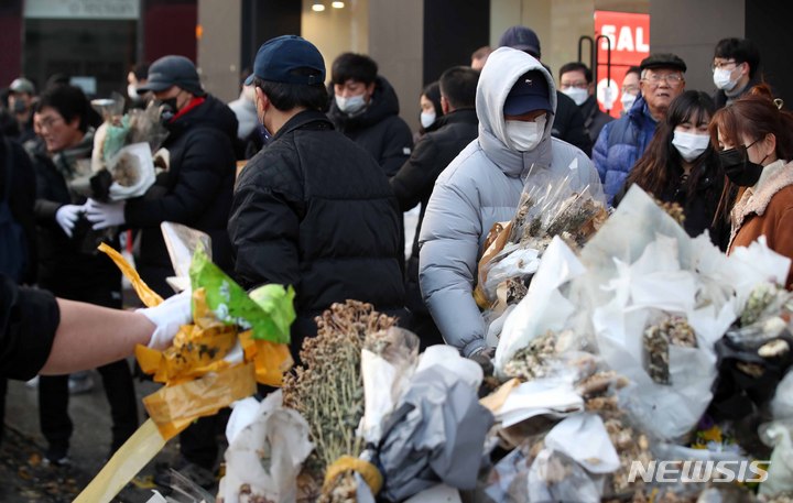 [서울=뉴시스] 김선웅 기자 = 이태원 참사 유가족협의회, 이태원 상인회, 자원봉사자 등이 21일 서울 용산구 이태원역 인근에 마련된 추모공간에서 참사 추모물품과 추모메시지 등을 정리하고 있다. 2022.12.21. mangusta@newsis.com