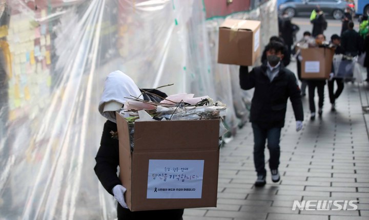 [서울=뉴시스] 김선웅 기자 = 이태원 참사 유가족협의회, 이태원 상인회, 자원봉사자 등이 21일 서울 용산구 이태원역 인근에 마련된 추모공간에서 참사 추모물품과 추모메시지 등을 정리하고 있다. 2022.12.21. mangusta@newsis.com
