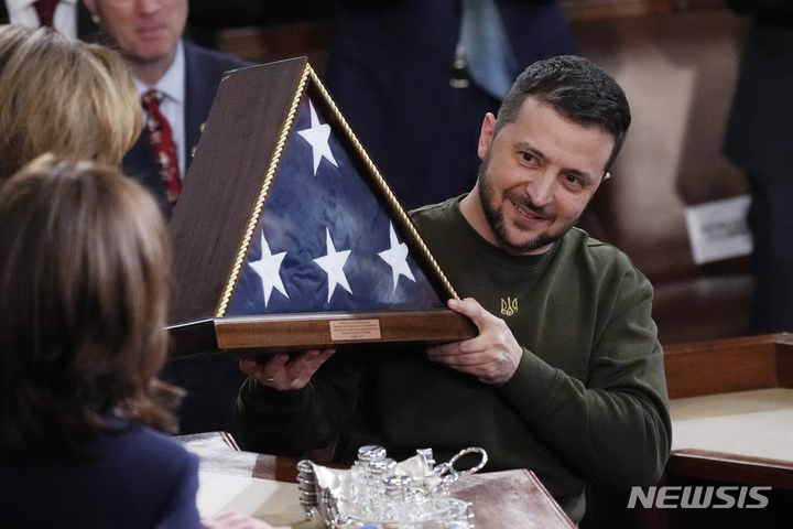 [워싱턴=AP/뉴시스]낸시 펠로시 하원의원이 볼로디미르 젤렌스키 우크라이나 대통령에게 성조기를 선물로 건네주고 있다. 2022.12.22 *재판매 및 DB 금지