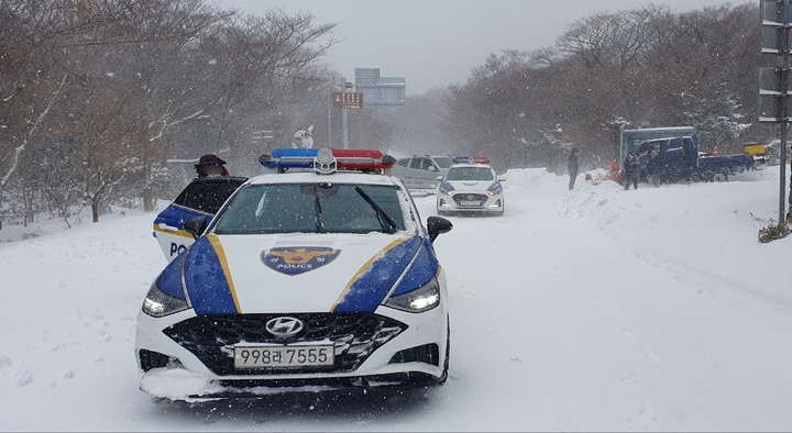 [제주=뉴시스] 오영재 기자 = 22일 오후 제주 한라산 인근 도로에서 폭설로 고립된 10여명이 출동한 경찰에 의해 구조되고 있다.(사진=제주경찰청 제공) 2022.12.22. photo@newsis.com *재판매 및 DB 금지