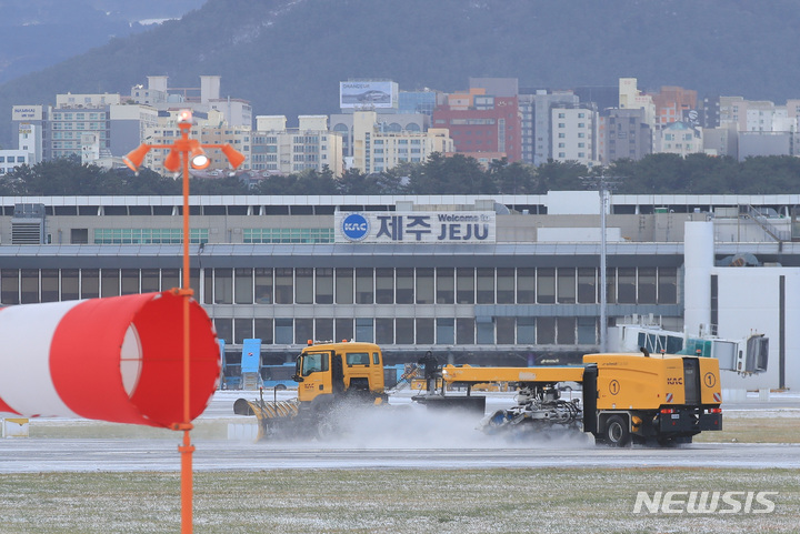 [제주=뉴시스] 우장호 기자 = 기상 악화로 제주 전역에 대설·강풍특보가 내려진 제주국제공항 활주로에서 제설차량이 눈을 치우고 있다. (뉴시스DB) woo1223@newsis.com