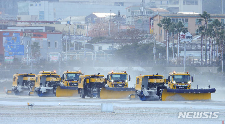 [제주=뉴시스] 우장호 기자 = 제주국제공항 활주로에서 제설차량이 눈을 치우고 있다. 2022.12.23. woo1223@newsis.com