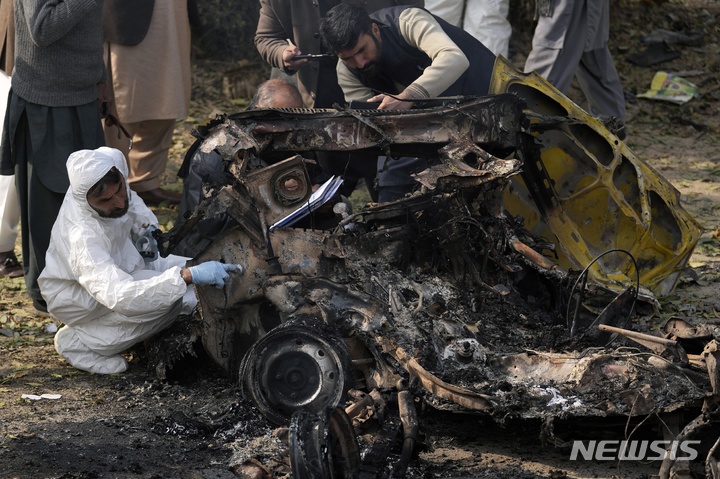 [이슬라마바드=AP/뉴시스] 23일(현지시간) 파키스탄 이슬라마바드의 폭탄 폭발 현장에서 수사관들이 폭탄 차량 잔해를 조사하고 있다. 경찰은 시내 한 검문소에서 남녀가 탑승한 자살폭탄 차량이 폭발해 경찰관 1명이 숨지고 다른 경관 2명과 시민 4명이 다쳤다고 밝혔다. 2022.12.23.