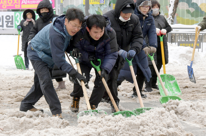 [광주=뉴시스]맹대환 기자 = 강기정 광주시장과 공무원들이 24일 북구 문흥동에서 지난 사흘 간 쌓인 눈을 치우고 있다. (사진=광주시 제공) 2022.12.24. photo@newsis.com *재판매 및 DB 금지