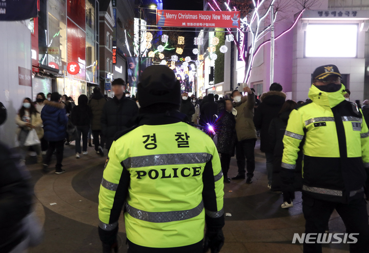 [서울=뉴시스] 최진석 기자 = 크리스마스 이브인 24일 서울 중구 명동거리에서 경찰이 질서 유지를 위해 시민들의 동선을 살펴보고 있다. 2022.12.24. myjs@newsis.com