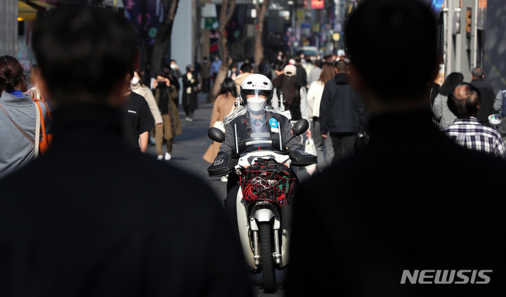 [서울=뉴시스] 추상철 기자 = 점심시간 서울 중구 명동거리에서 통신 수리기사가 오토바이를 타고 이동하고 있다. 2022.12.30. scchoo@newsis.com