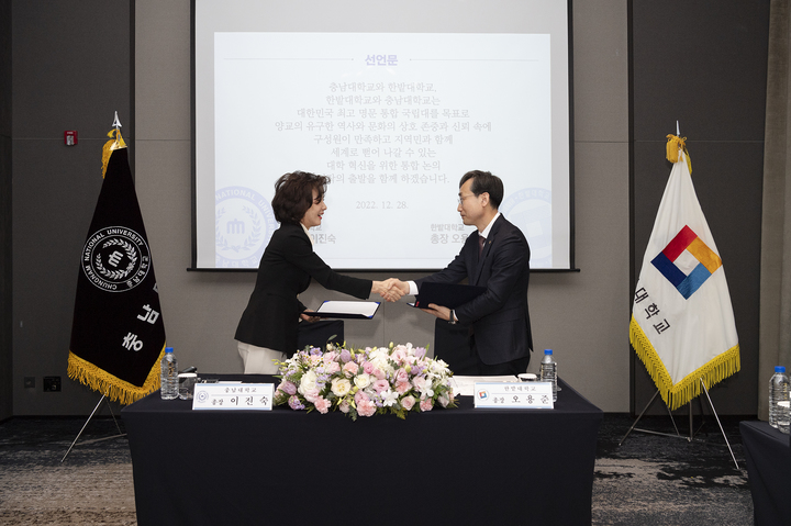 [대전=뉴시스] 지난해 12월28일 대전 유성구 호텔오노마에서 대학통합 논의 공동선포식을 연 충남대 이진숙(왼쪽) 총장과 한밭대 오용준 총장이 공동선식에서 악수를 나누고 있다. 2023.05.10. photo@newsis.com *재판매 및 DB 금지 *재판매 및 DB 금지