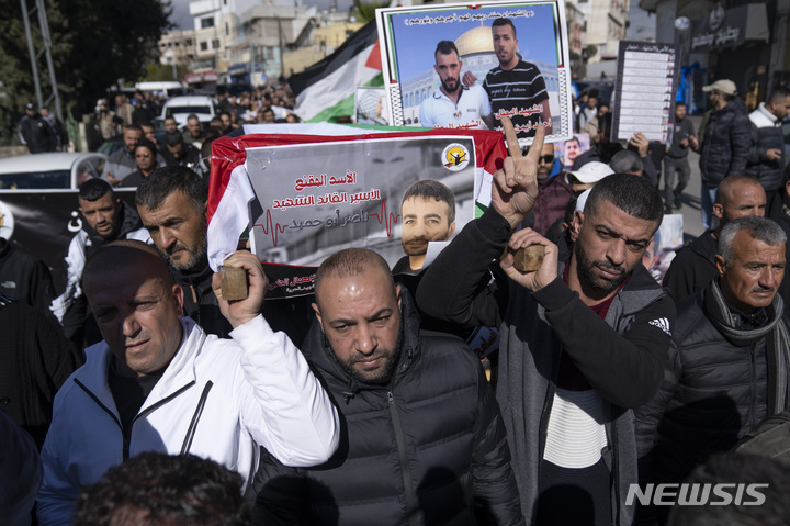 [라말라=AP/뉴시스] 27일(현지시간) 라말라 남쪽 서안지구 칼란디아 난민캠프 인근에서 팔레스타인 시위대가 지난주 이스라엘 구금 중 폐암으로 사망한 팔레스타인 수감자 나세르 아부 하미드의 모의 관을 들고 시위하고 있다. 시위대는 아부 하미드와 다른 팔레스타인 사람들의 시신을 돌려줄 것을 요구하며 이스라엘 군인들과 충돌했다. 2022.12.28.